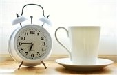 Photo of a clock and a cup of coffee