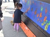 Girl leaving handprint on snowplow blade