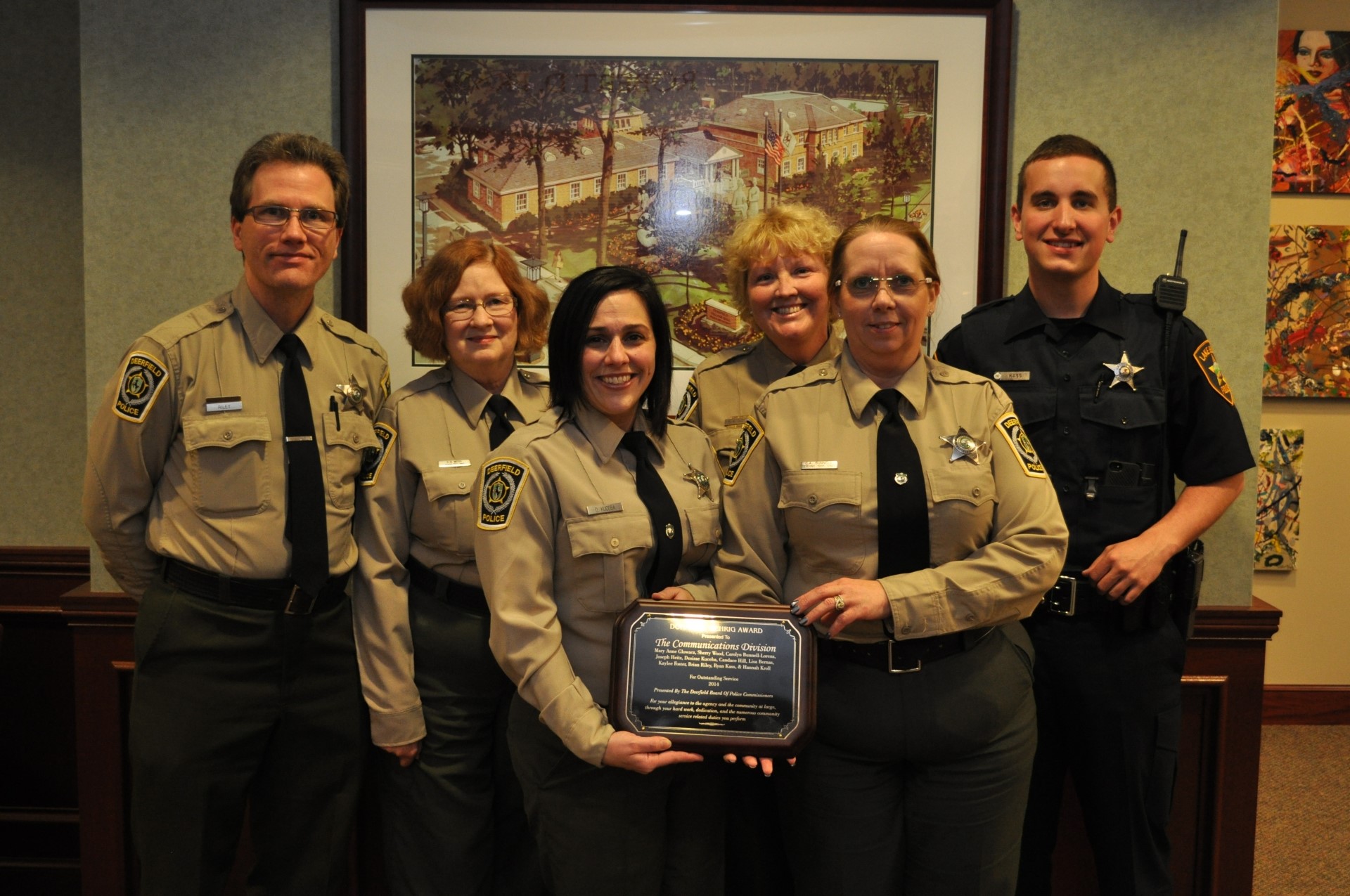 Six communications staff standing with award